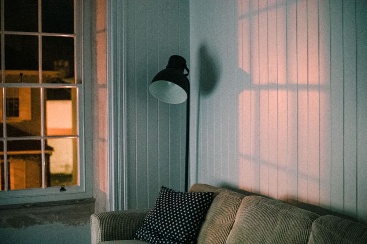 Lampadaire liseuse salon avec bras orientable près d'un fauteuil de lecture