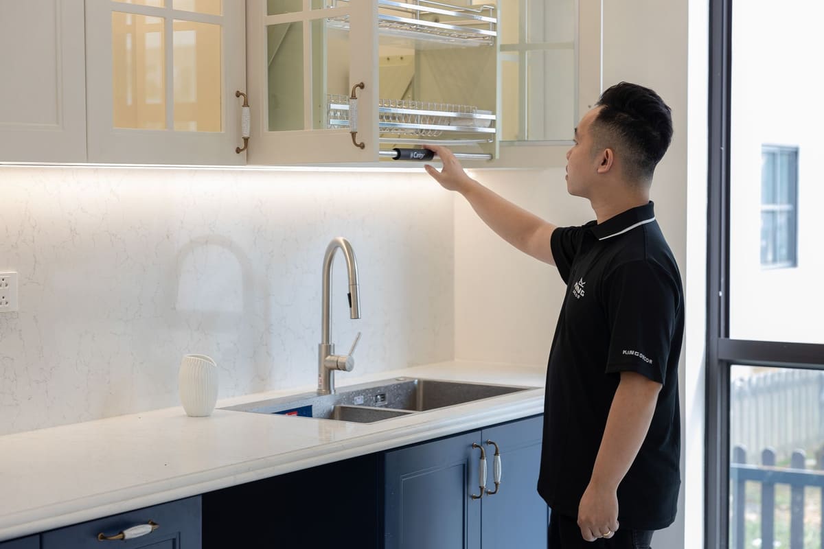 Technicien en train d'installer un lave-vaisselle encastrable dans une niche de cuisine