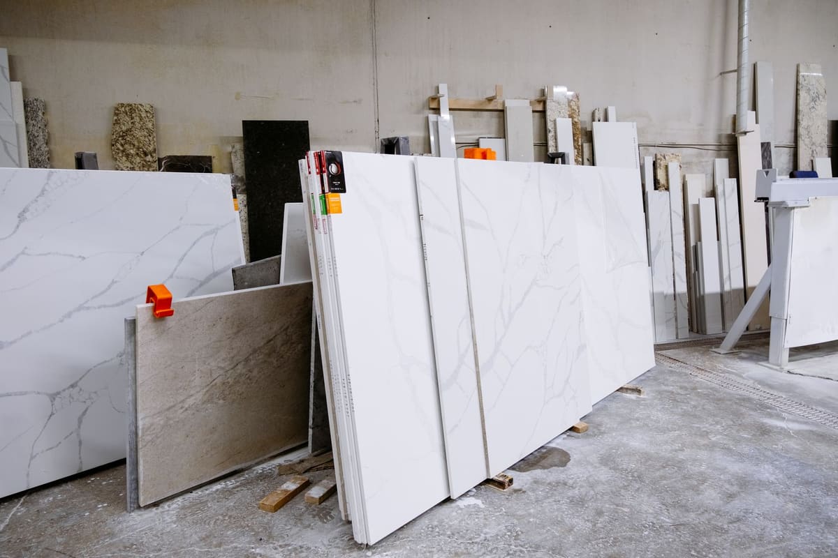 Échantillons de plan de travail en quartz, granit et stratifié posés côte à côte